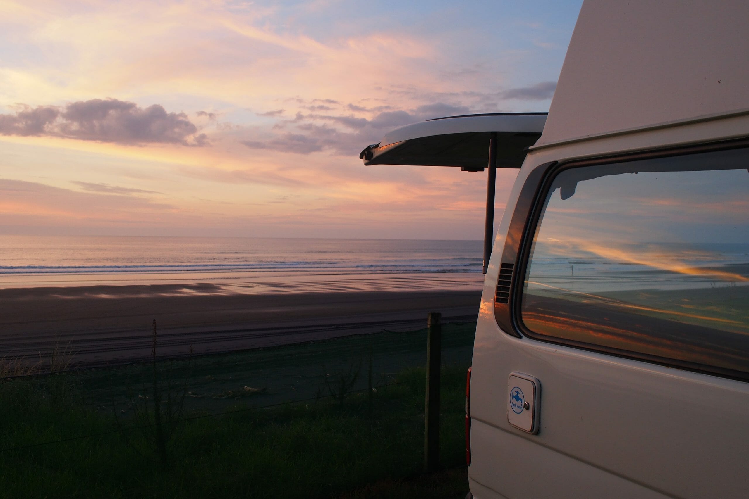 Nuit en road trip, van avec une vue sur la plage au coucher de soleil